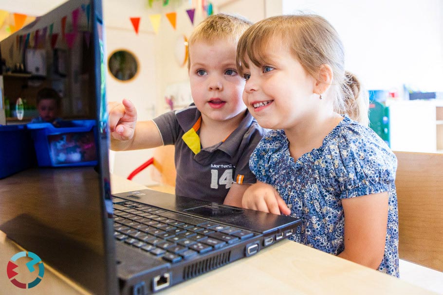 Twee kinderen achter een laptop op het kinderdagverblijf.