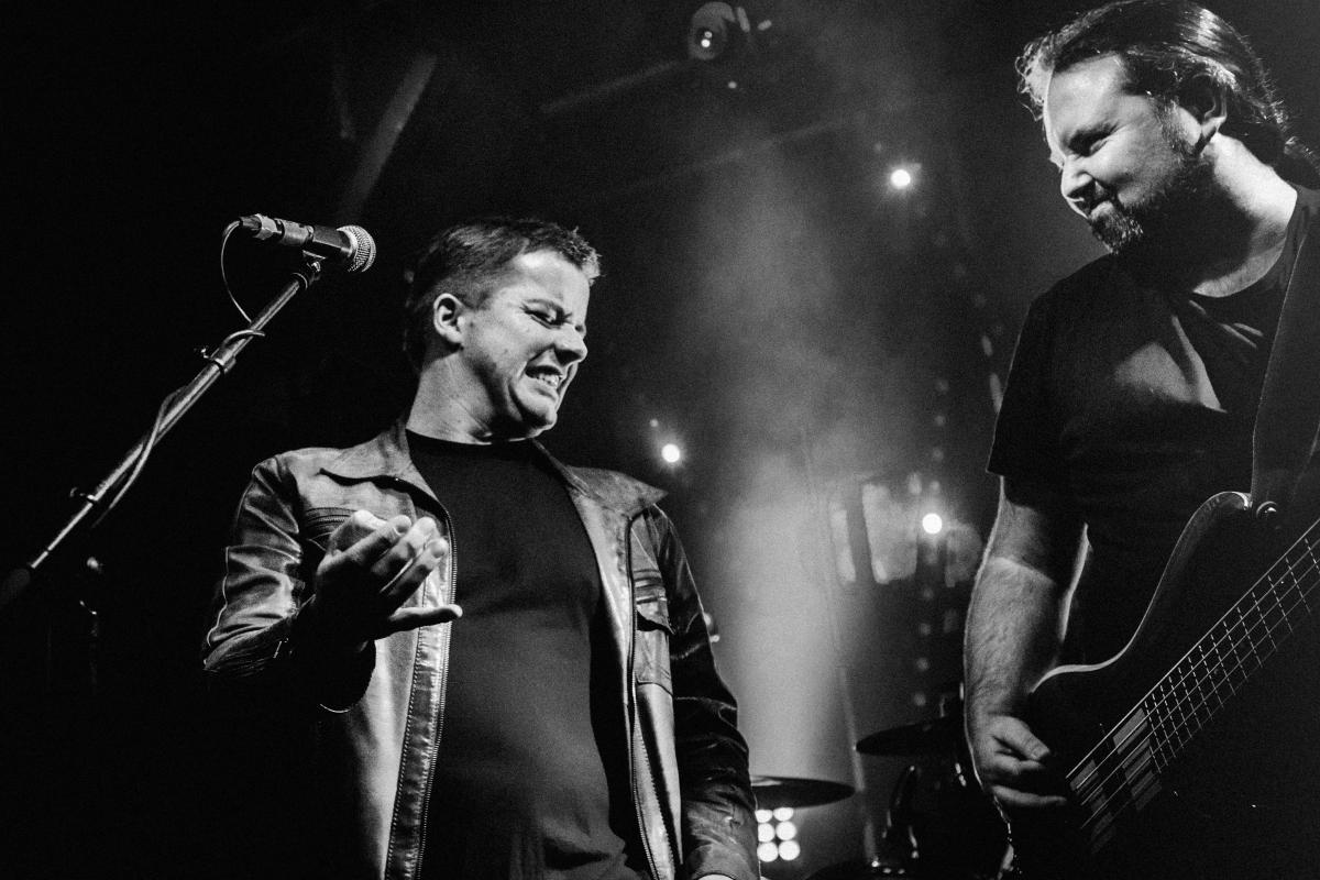 Concertfoto van zanger die luchtgitaar speelt