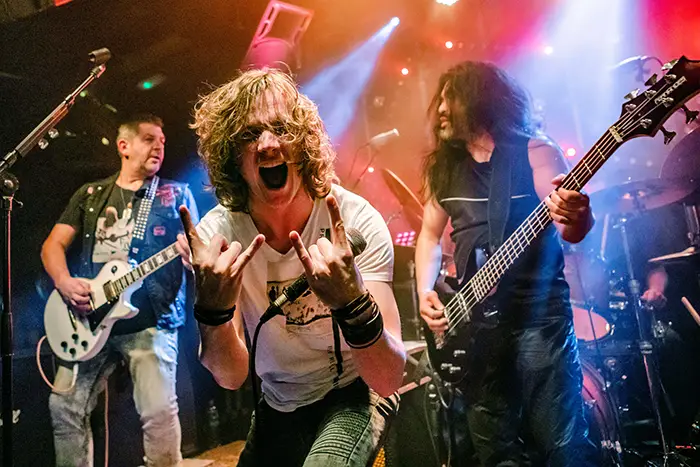 Zakelijke fotografie van hardrock band op podium tijdens live concert Den Bosch